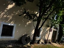 Außenfassade mit Mühlsteinen und Laubbäumen